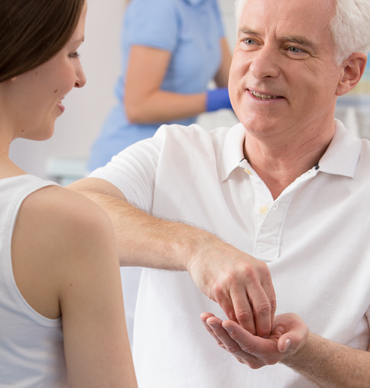 A doctor showing a patient how to disinfect her hands